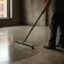 Smoothing wet concrete floor with squeegee