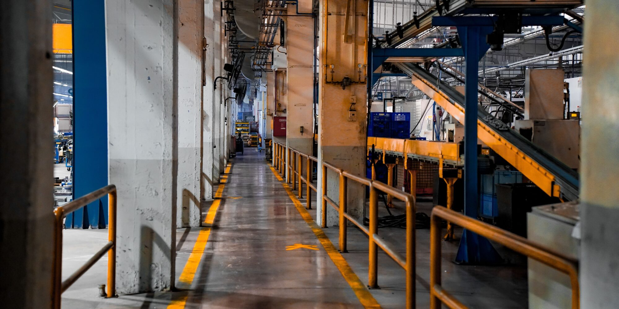 Ett industrigolv med en markerad gångbana i en produktionshall, idealiskt för en jämförelse mellan epoxy och polyuretan.