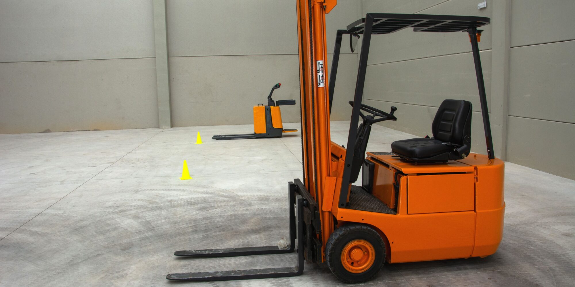 En gaffeltruck på ett industrigolv av betong med däckspår, vilket visar behovet av regelbundet golvunderhåll i logistikcenter.