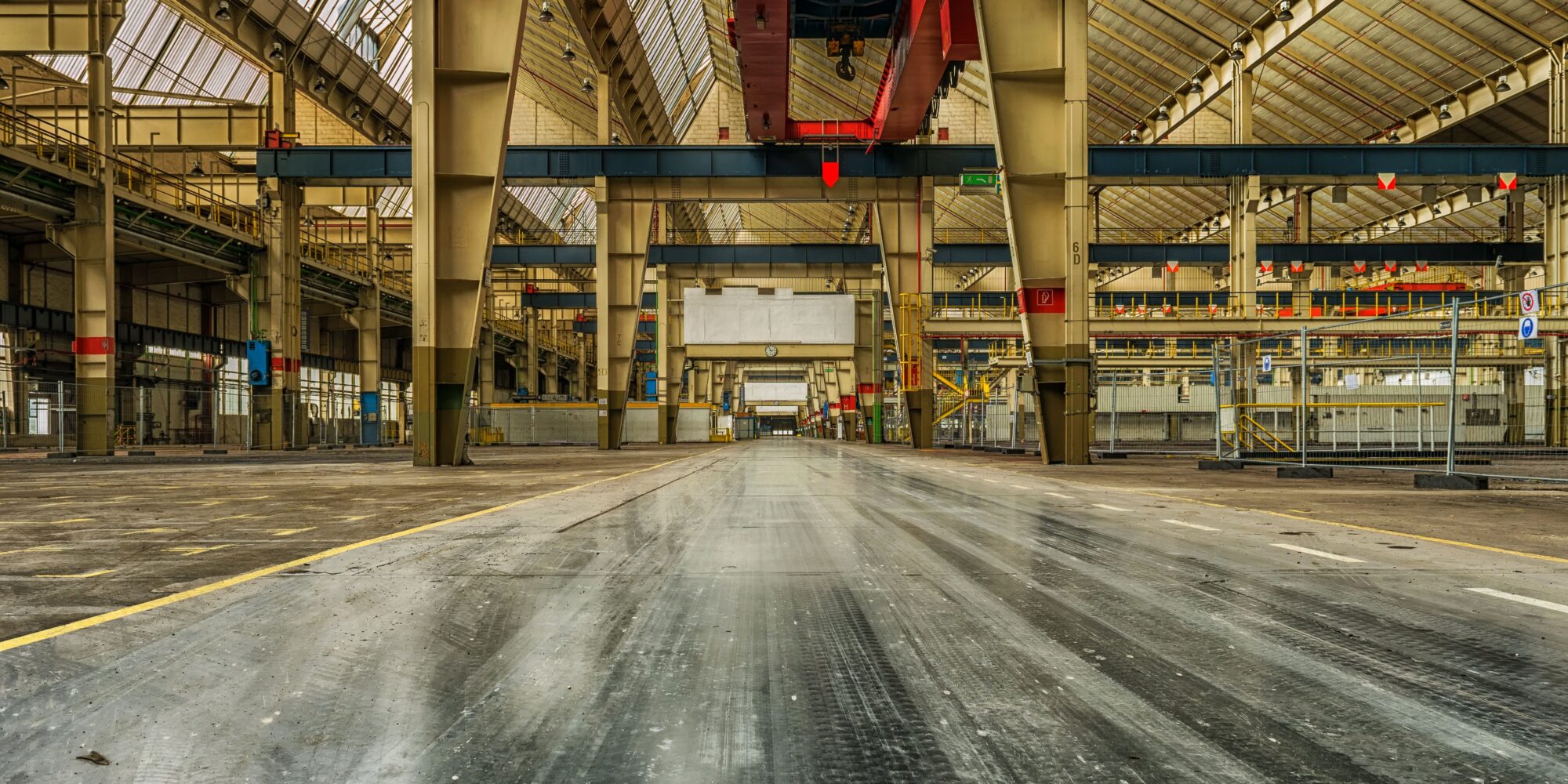Ett högpresterande, ljust industrigolv i en stor logistikanläggning med lastbilsportar, vilket minimerar livscykelkostnaden (LCC).