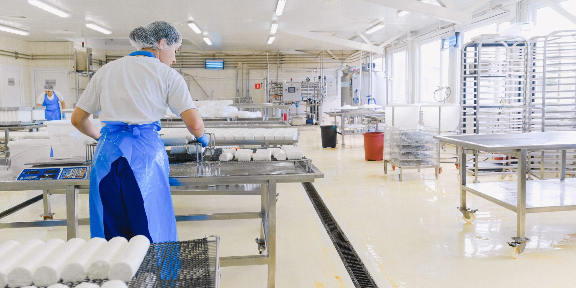 Ett ljust, sömlöst och hygieniskt epoxigolv under en produktionslinje i en modern livsmedelsanläggning.
