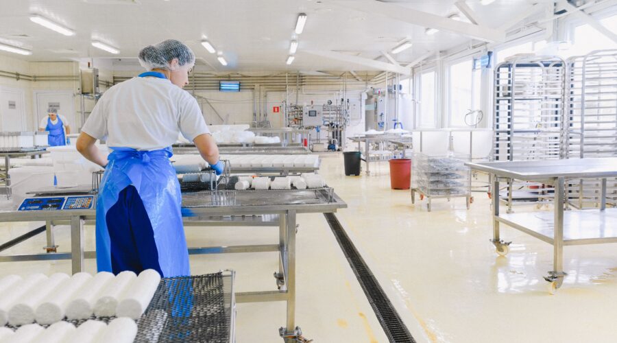 Ett ljust, sömlöst och hygieniskt epoxigolv under en produktionslinje i en modern livsmedelsanläggning.