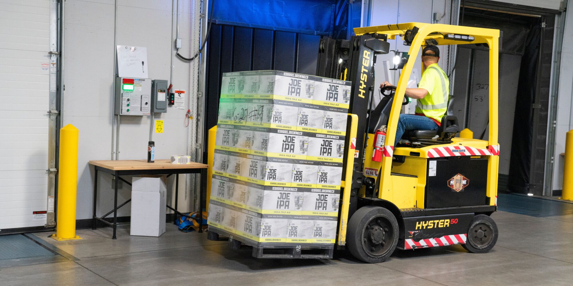 En gaffeltruck hanterar gods på ett industribetonggolv vid en lastkaj i ett lager