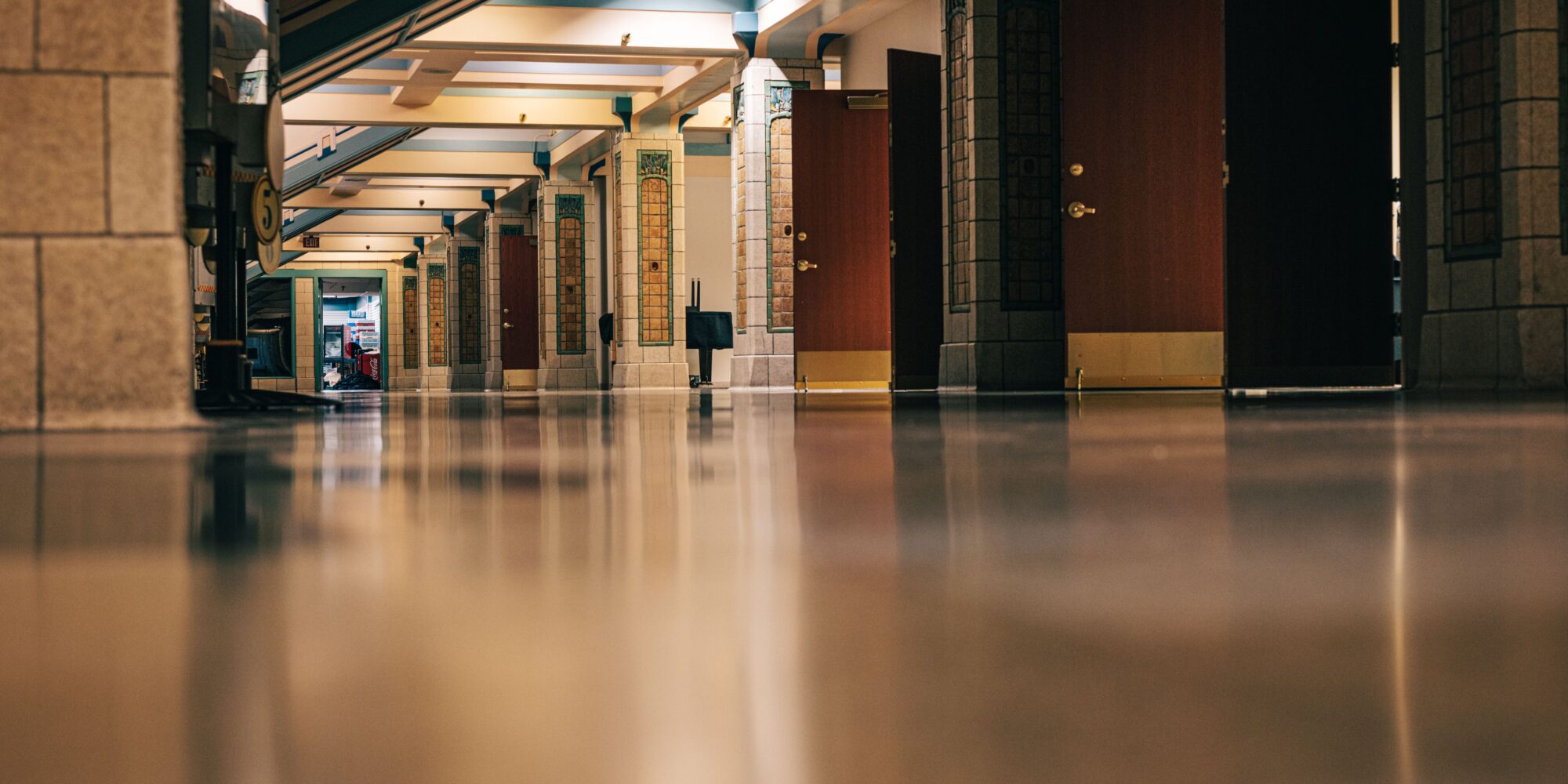 Ett blankt, tåligt och dammfritt betonggolv i en korridor i en offentlig byggnad eller skola efter golvbehandling.